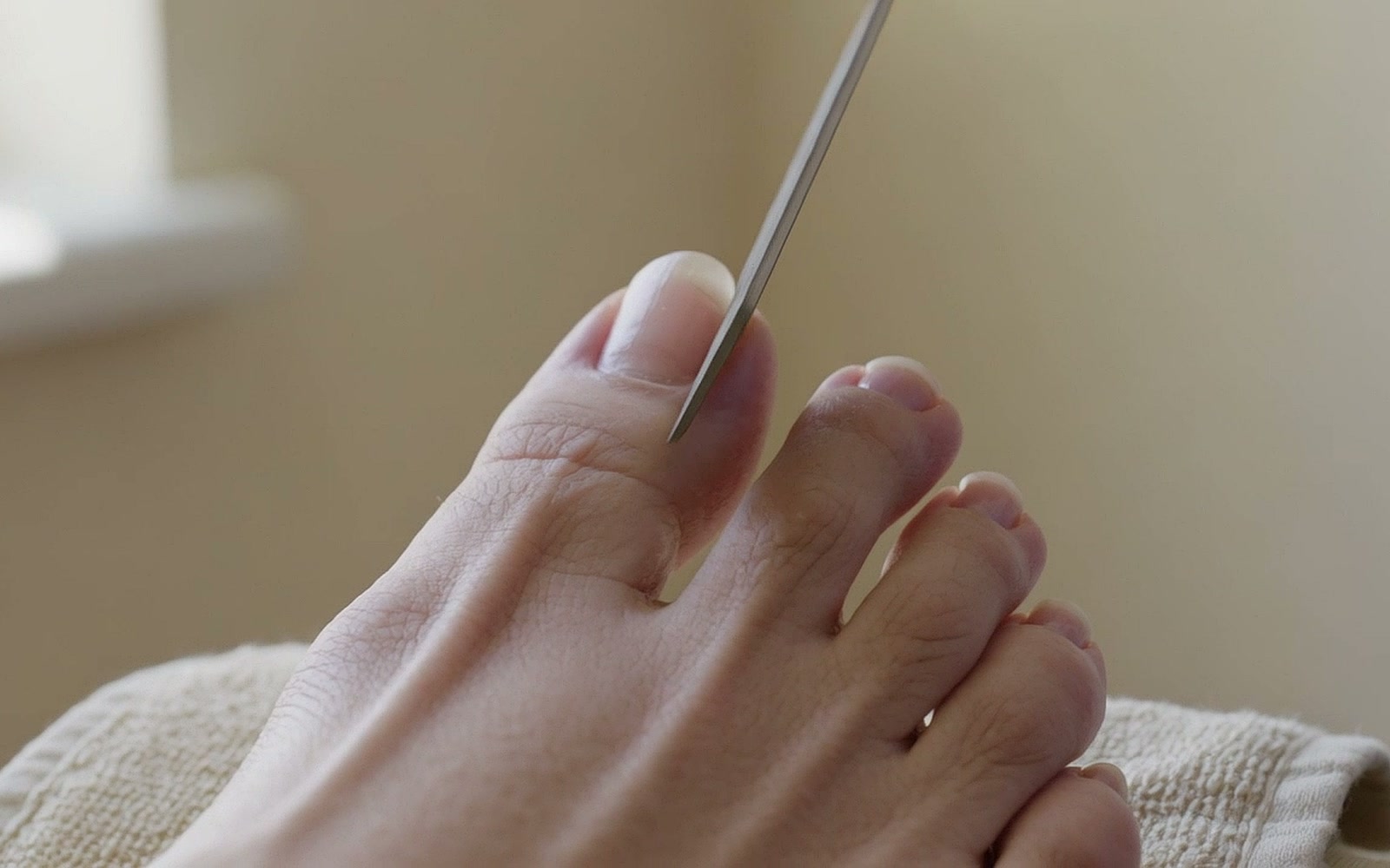 Eine Feile bringt die Kante des großen Zehennagels in Form